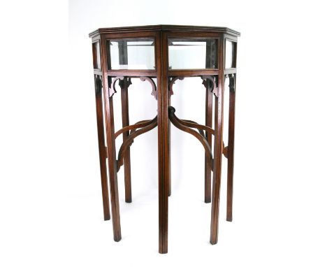 A reproduction Edwardian style mahogany octagonal curio table, the glazed top and sides on eight legs, united by unswept stre