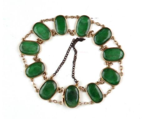 A yellow metal and jade panel bracelet, the eleven rub-over set oval jade panels united by chain links, the integral clip sta