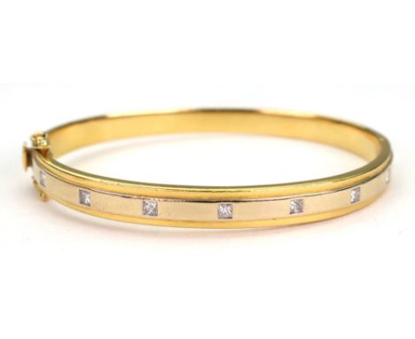 A two colour gold and diamond-set hinged bangle, the central band set with seven calibre-cut diamonds, stamped '750', 66mm wi