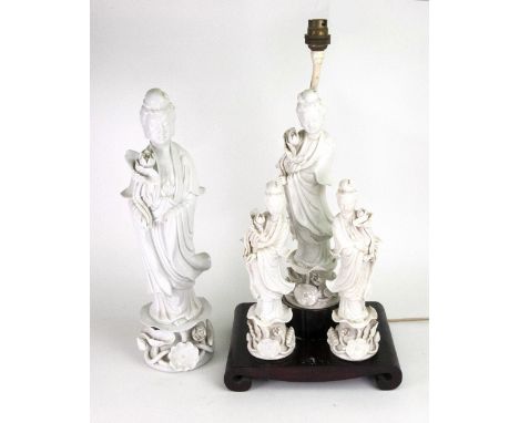 Three Chinese blanc de chine figures of Guanyin, 20th century, each standing holding a lotus flower, adapted as a table lamp 