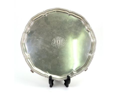 A George III style silver shaped circular salver, Harrison Brothers & Howson, Sheffield 1916, moulded and gadroon border, on 