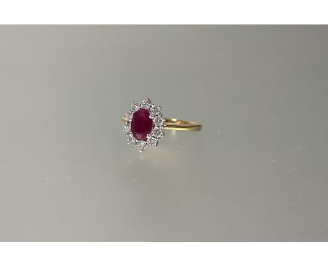 An 18ct gold ruby and diamond cluster ring, the oval ruby approxiametely 0.5ct, and ten brillaiant cut diamonds approximately