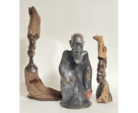 A group of African tribal art carved wood sculptures comprising a seated figure, and two naturalistic carved wooden figures (