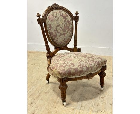 A heavily carved Victorian walnut side chair with tapestry seat and back, with brass caps and china castors (h.87cm)