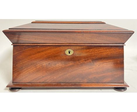 A nicely figured Regency mahogany sarcophagus form tea caddy with interior compartments, and later mixing bowl, raised on bun