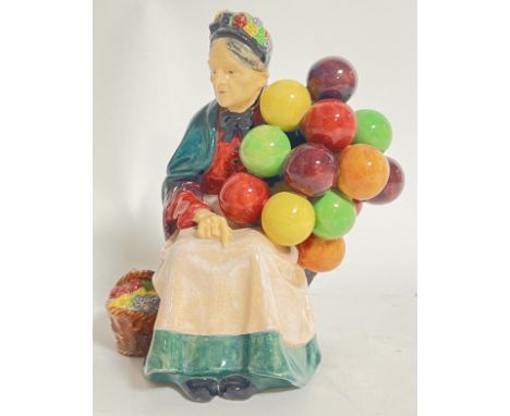 A brightly glazed Royal Doulton 'Old Balloon seller' ceramic figure of a seated lady (marked verso, h- 20cm, w- 17cm)