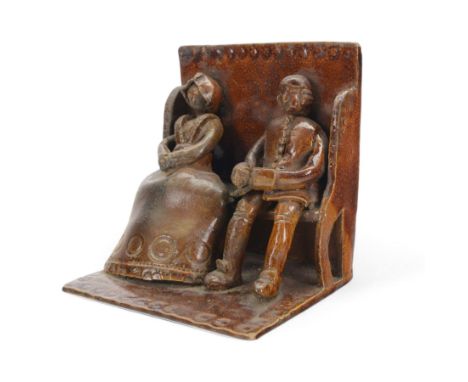 Treacle glaze figures group, modelled as a couple seated in a pew, H17cm