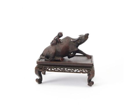 Chinese carved hardwood model of an ox or water buffalo, with attendant upon back, upon a carved openwork stand with cabriole