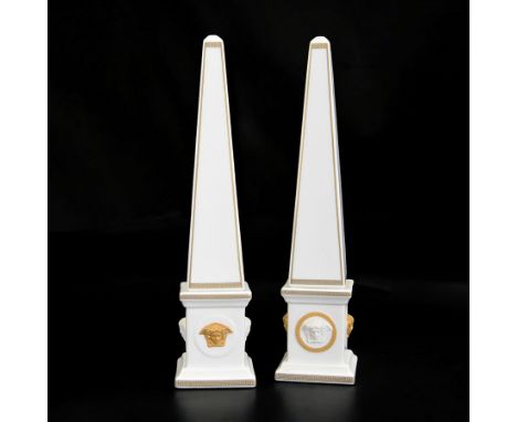 Pair of Rosenthal Versace Gorgona obelisks, each with relief moulded Medusa masks and gilt Greek key borders upon a white gro