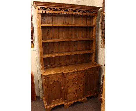 Pine dresser, the shelf back above a breakfront base of four drawers and two carved panel doors, 143cm by 215cm.