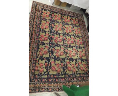A Caucasian rug, the central panel set with repeating floral sprays on a dark blue ground within a stepped blue, green and pi