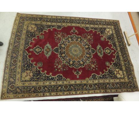A Tabriz carpet, the central mustard and blue medallion with stylised floral decoration in terracotta, blue and green on a re