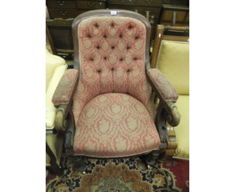 A 19th Century mahogany framed button back salon chair on carved and turned front supports to brass castors
