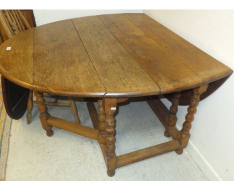 An early 20th Century oak oval gate-leg drop-leaf dining table on bobbin turned supports in the 17th Century manner