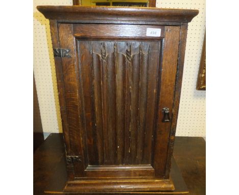 An oak dwarf cabinet in the 16th Century manner, the linenfold door enclosing one shelf (incorporating early components)