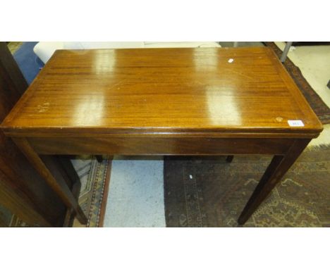 A mahogany fold over card table with chequer board top within a green baize, raised on square tapered legs