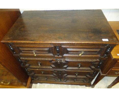 An oak chest in the 17th Century manner, the two piece top with moulded edge above four long graduated drawers with brass tea