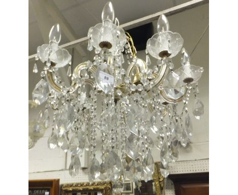 An eight branch brass and glass drop ceiling light fitting