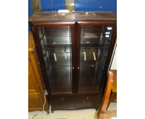 A Stag Minstrel glazed display cabinet with two doors over two panelled cupboard doors on bracket feet