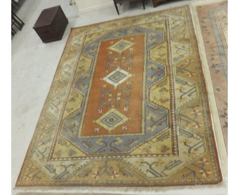 A Caucasian carpet decorated with rectangular panels in terracotta, blue, yellow and cream, decorated with diamond and geomet