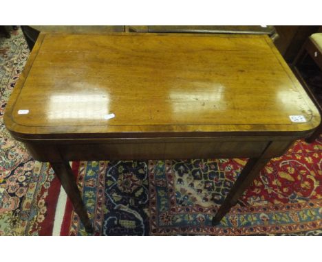 An early 19th Century mahogany and inlaid fold over card table with square tapering legs to spade feet