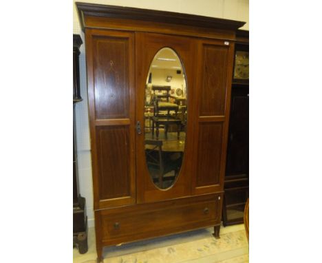 An Edwardian mahogany and inlaid single mirror door wardrobe with drawer beneath