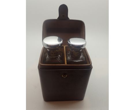 Hallmarked silver lidded glass leather cased pair of perfume bottles