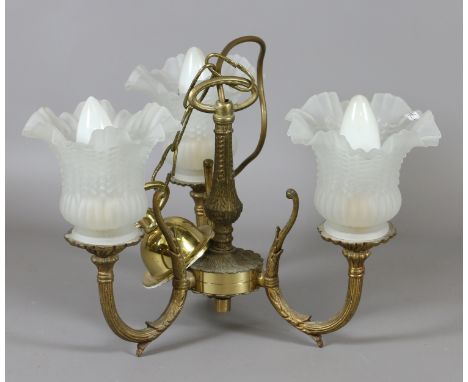 A brass three arm hanging ceiling lamp with frosted glass shades.