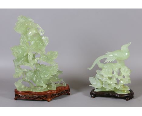 Two Chinese jade coloured hardstone carvings on hardwood stands. One formed as a kirin and its young and the other depicting 