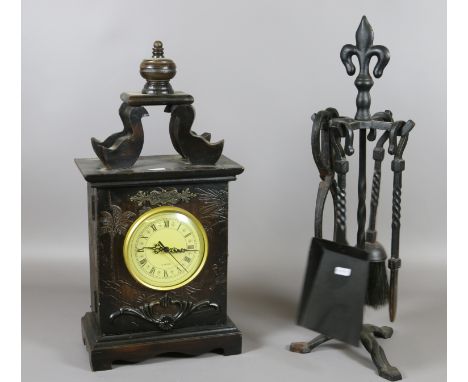 A wrought iron companion set along with a modern clock.