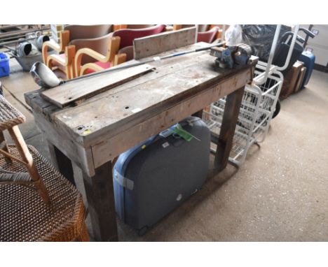 A wooden work bench with fitted bench vice