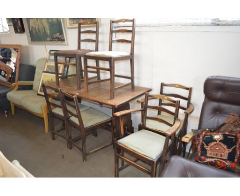 An oak refectory dining table; together with a set of six ladder back chairs to include two carvers