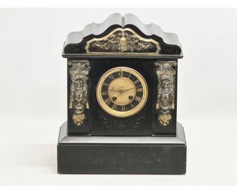 A Victorian slate mantle clock, with brass mounts. Key and pendulum. 30x15x35cm