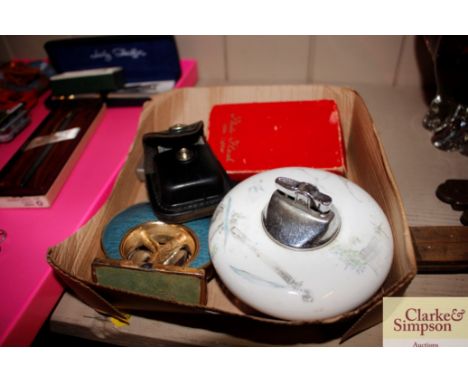 A box containing various lighters to include a Photoflash table lighter, a Rosenthal table lighter, Zippos etc.