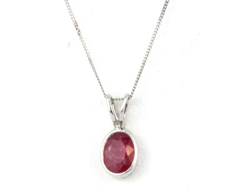 A 9ct white gold (stamped 375) pendant and chain set with an oval cut ruby, L. 1.5cm.