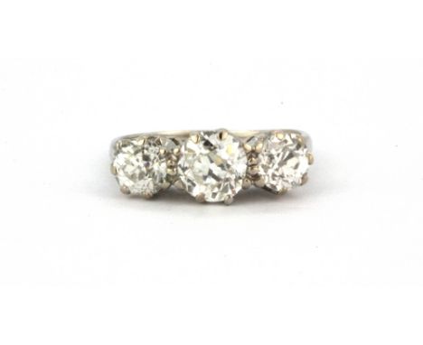 A white metal (tested platinum) ring set with three old cut diamonds, approx. 1.6ct overall, (K).