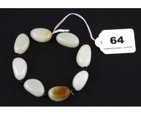 A Chinese bracelet of white and russet pebble jade beads, bead L. 2.5cm.