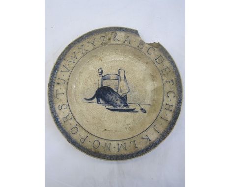 A Delft blue and white plate with alphabet rim, decorated with kitten at table drinking milk from a dish, marked to reverse, 