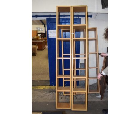 A pair of modern light wood narrow bookcases