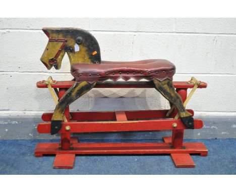 A VINTAGE TRESTLE ROCKING HORSE with a red leatherette seat