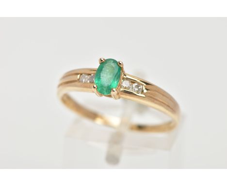 AN EMERALD RING, oval cut emerald measuring approximately 6mm x 4mm, prong set, also featuring four round brilliant cut diamo