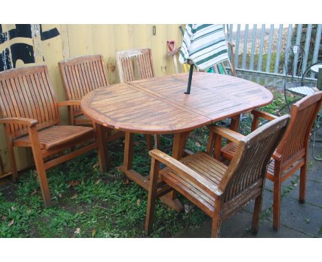 A TEAK OVAL EXTENDING GARDEN TABLE, open length 172cm x closed length 122cm x width 90cm x height 72cm with a set of five cha