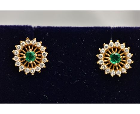 A PAIR OF 18CT GOLD EMERALD AND DIAMOND EARRINGS, each of an openwork circular design, centring on a circular cut emerald, wi