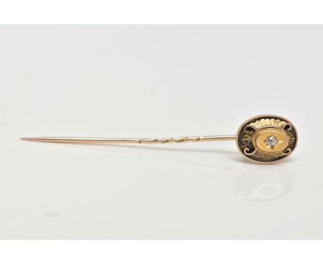 A YELLOW METAL DIAMOND SET STICK PIN, the head of an oval design centring on a star set old cut diamond, rope twist surround 
