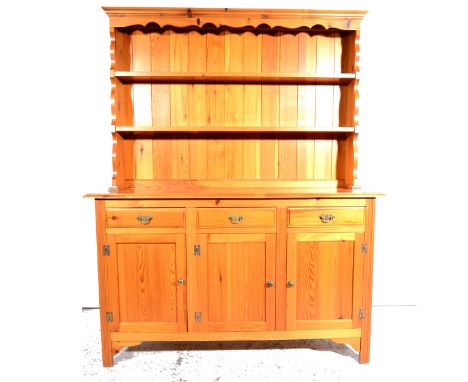 A modern pine dresser, two-shelf delft rack, base with three drawers over three panelled doors, width 142cm.