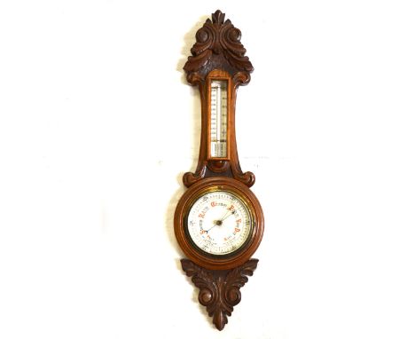 An oak cased aneroid barometer with thermometer, 12cm dial, carved acanthus leaves to top and bottom, 66cm