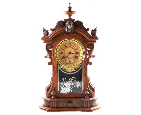 An Ansonia shelf clock, circular arabic dial with a turquoise and gilt bezel of leaves, stained wooden case with plinth base 