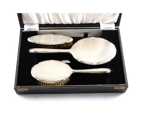 A cased silver backed dressing table set comprising two brushes and a hand mirror, engine turned design by S J Rose &amp; Son