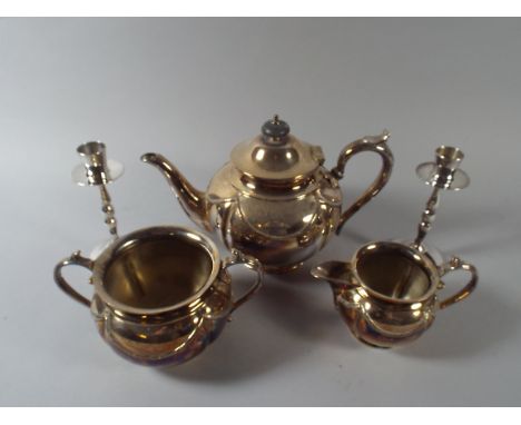 A Silver Plated Three Piece Tea Service and A Pair of Chromed Candle Sticks