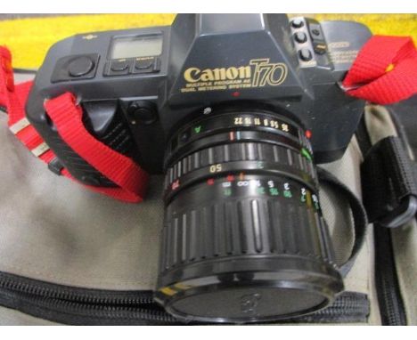 A vintage Canon T70 camera in a case with accessories 